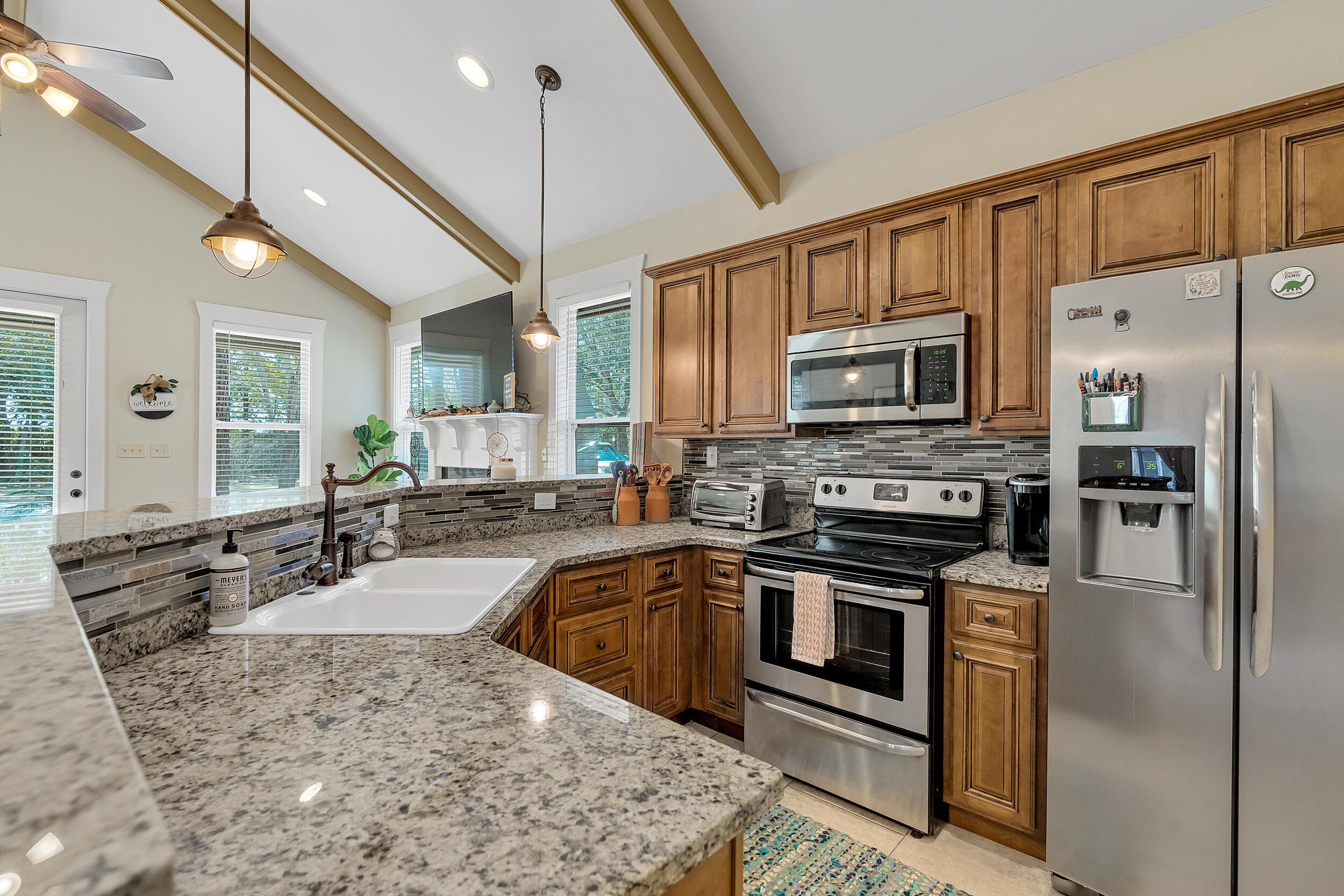 719 Earl Godwin Road Freeport, FL 32439 - Photo 11 of 23 a kitchen with stainless steel appliances granite countertop a sink a stove top oven a refrigerator with island and chairs