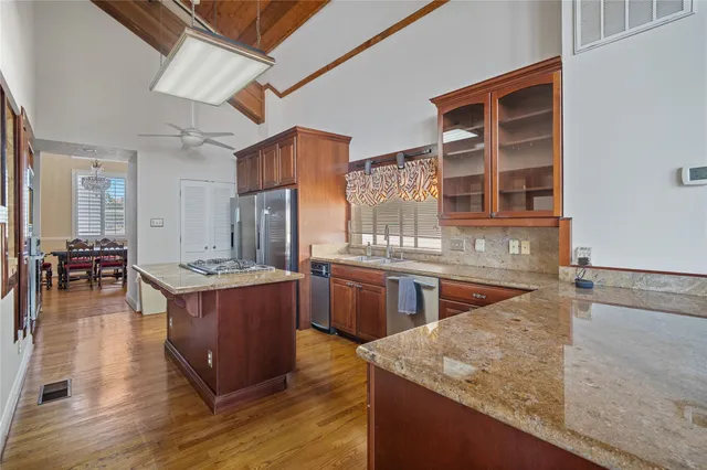 a living room with stainless steel appliances furniture a rug and a window