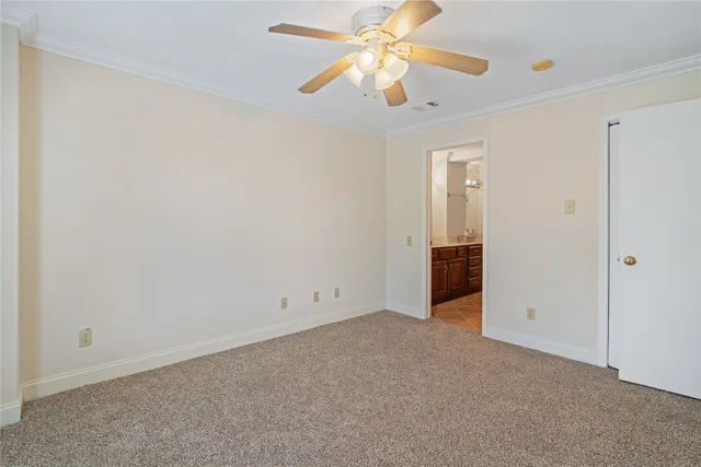 an empty room with closet and a chandelier fan