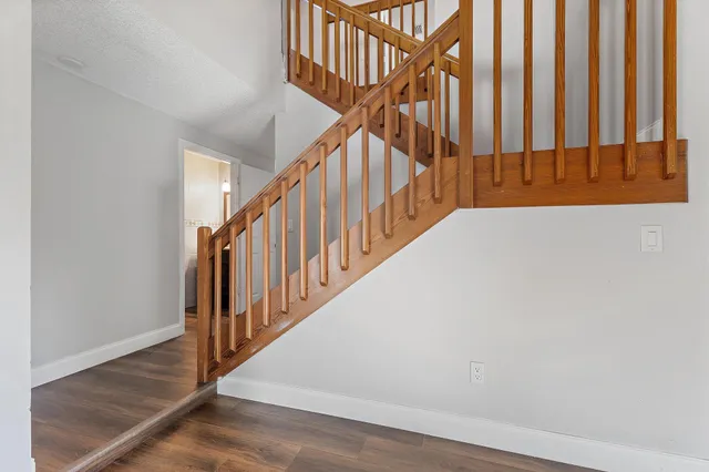 a view of a livingroom with wooden floor and stairs