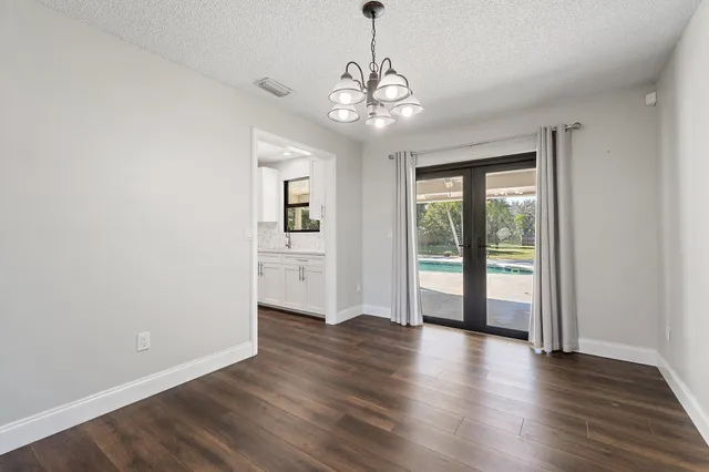a kitchen with granite countertop a refrigerator stove and sink