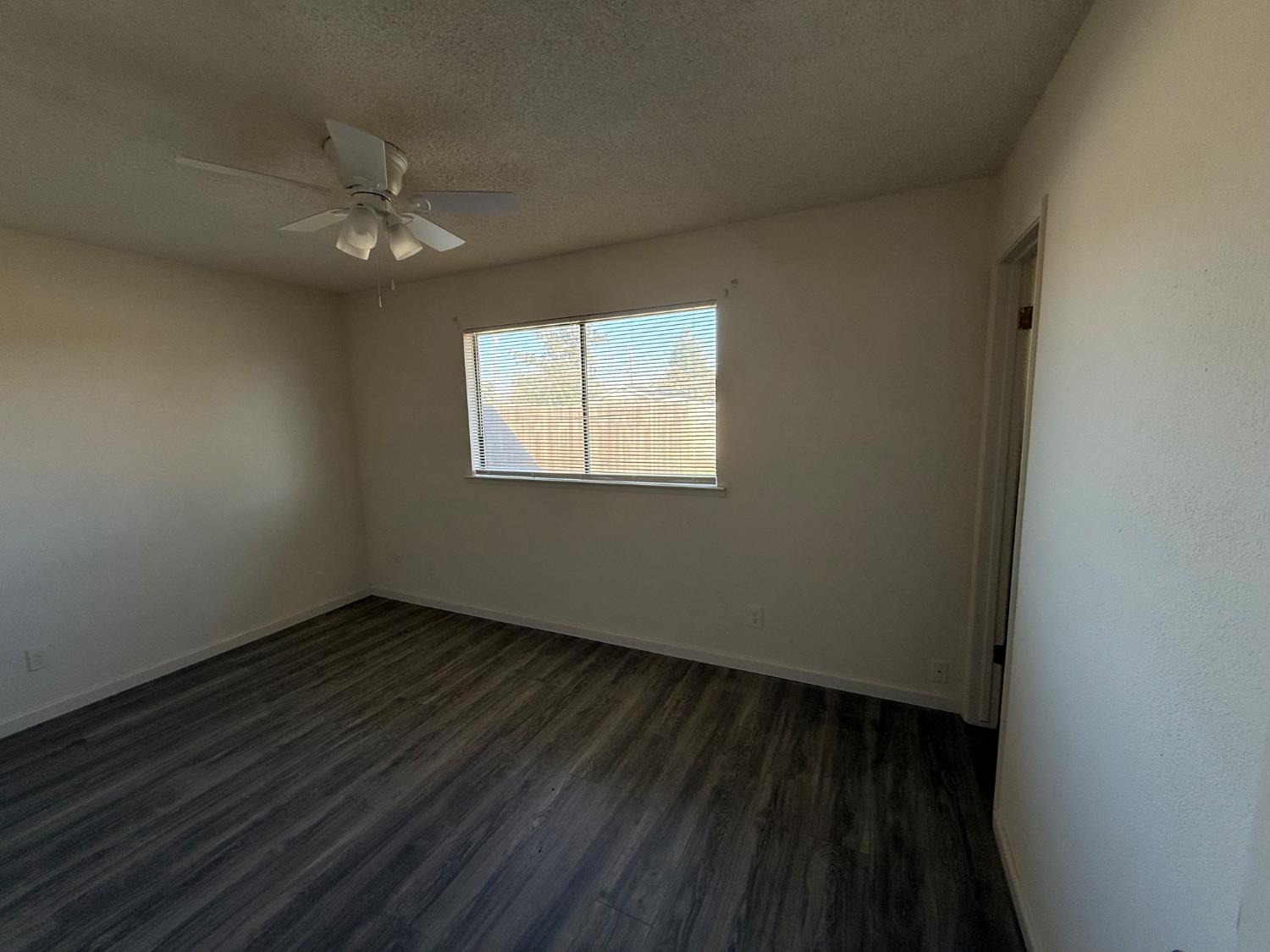 16385 North D Street Madera, CA 93638 - Photo 11 of 26 a view of an empty room with wooden floor and a window