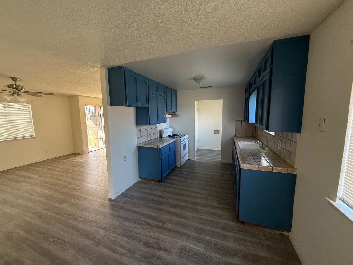 16385 North D Street Madera, CA 93638 - Photo 3 of 26 a kitchen with stainless steel appliances granite countertop a refrigerator a sink dishwasher a stove and white countertops with wooden floor