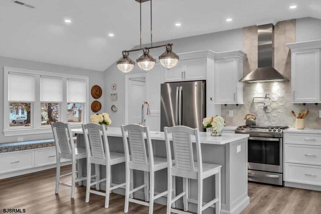 1610 Shore Road Linwood, NJ 08221 - Photo 15 of 46 a kitchen with stainless steel appliances kitchen island granite countertop a table chairs sink and stove top oven