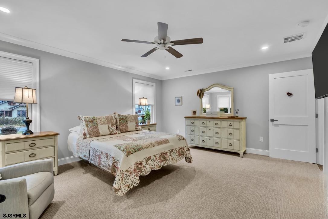 1610 Shore Road Linwood, NJ 08221 - Photo 25 of 46 a bedroom with a bed a dresser and a chandelier
