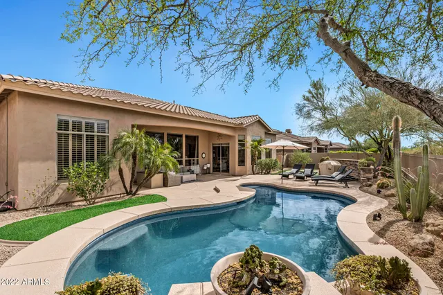 a view of a house with backyard sitting area and swimming pool