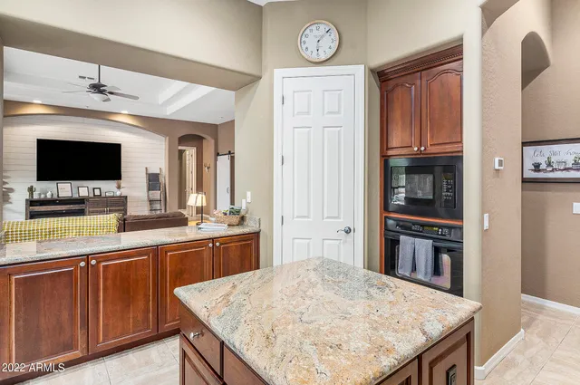 a kitchen with stainless steel appliances granite countertop a stove top oven a sink dishwasher and a refrigerator with wooden floor