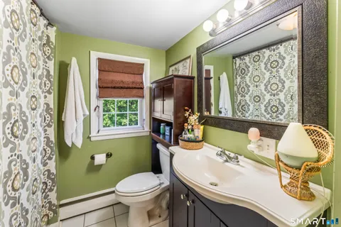 a bathroom with a sink toilet and window