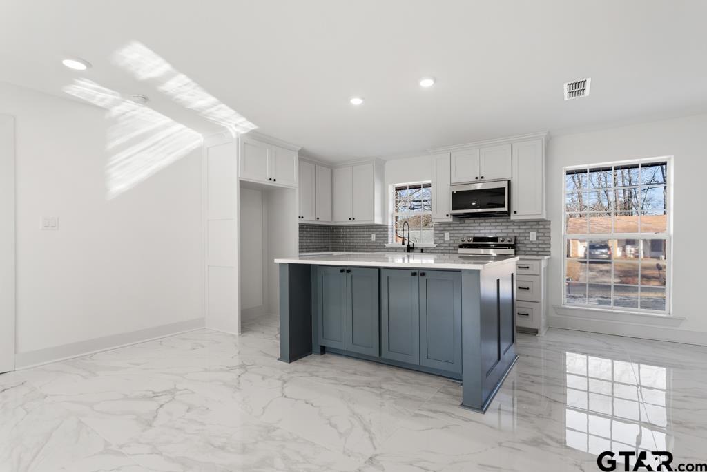 1608 Austin Drive Tyler, TX 75701 - Photo 15 of 36 a kitchen with granite countertop a stove a sink and a refrigerator