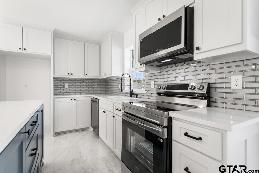 1608 Austin Drive Tyler, TX 75701 - Photo 16 of 36 a kitchen with stainless steel appliances granite countertop a sink stove and microwave