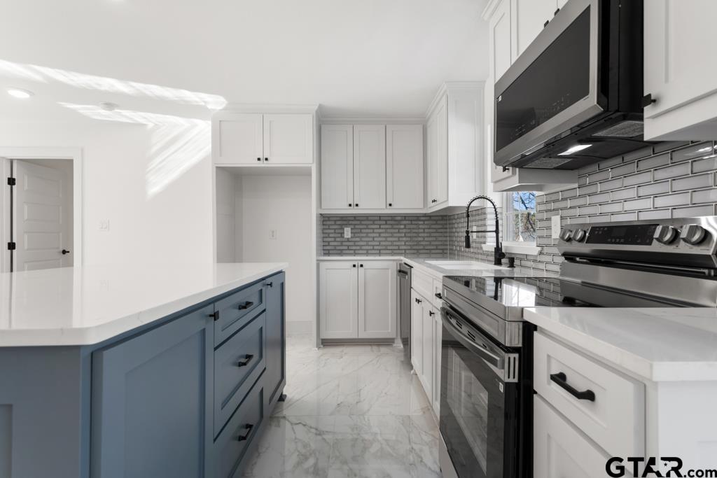 1608 Austin Drive Tyler, TX 75701 - Photo 17 of 36 a kitchen with stainless steel appliances granite countertop a sink stove and microwave