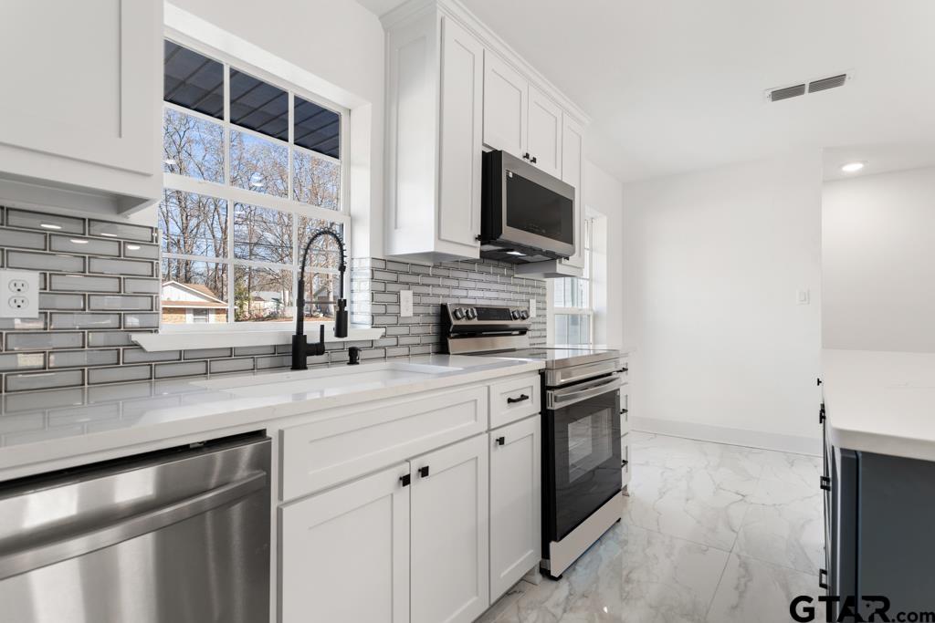 1608 Austin Drive Tyler, TX 75701 - Photo 18 of 36 a kitchen with stainless steel appliances granite countertop a sink and a stove