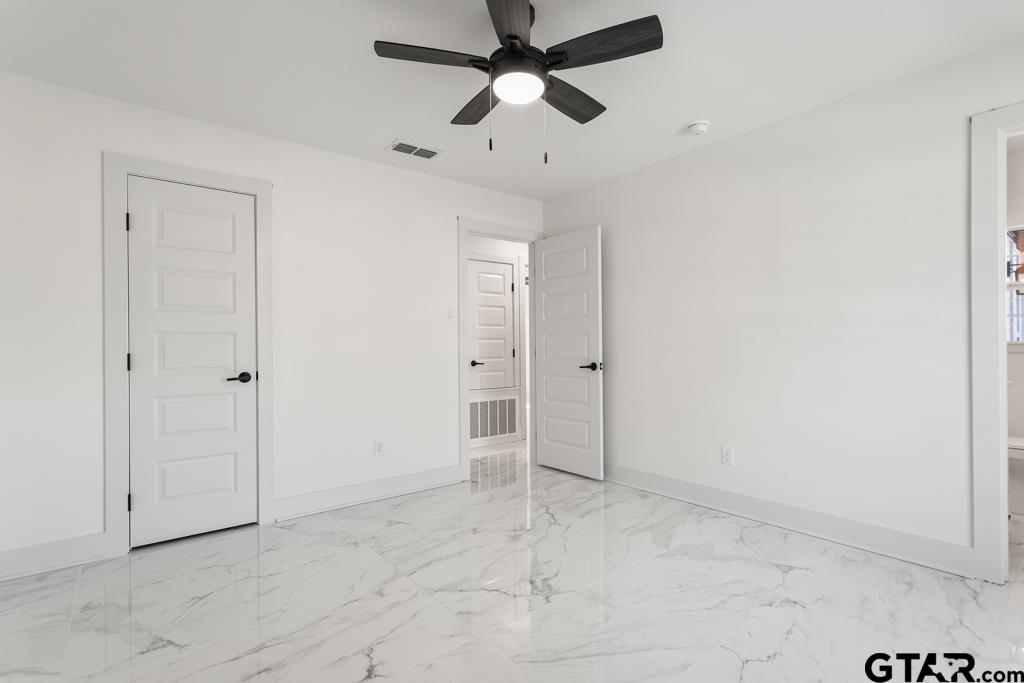 1608 Austin Drive Tyler, TX 75701 - Photo 24 of 36 an empty room with closet and a ceiling fan