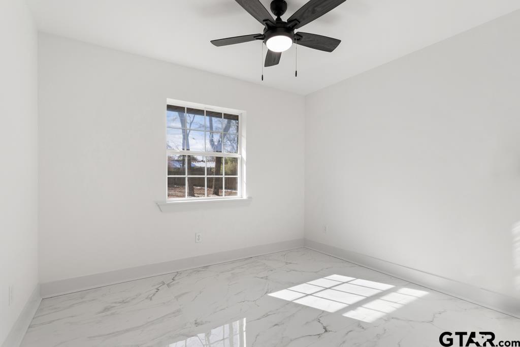 1608 Austin Drive Tyler, TX 75701 - Photo 26 of 36 an empty room with windows and fan