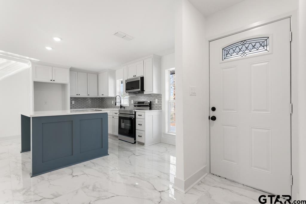 1608 Austin Drive Tyler, TX 75701 - Photo 6 of 36 a kitchen with granite countertop a refrigerator and cabinets