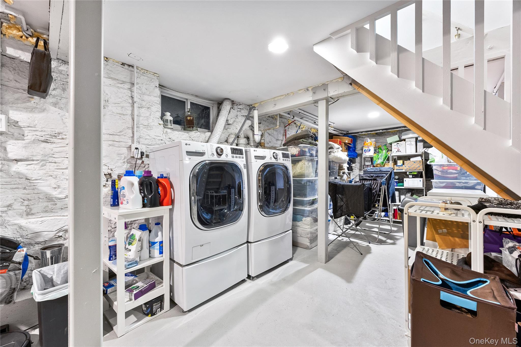 19 Howe Place Bronxville, NY 10708 - Photo 35 of 37 Laundry area with white painted stone walls, recessed lighting, and a white open-tread staircase