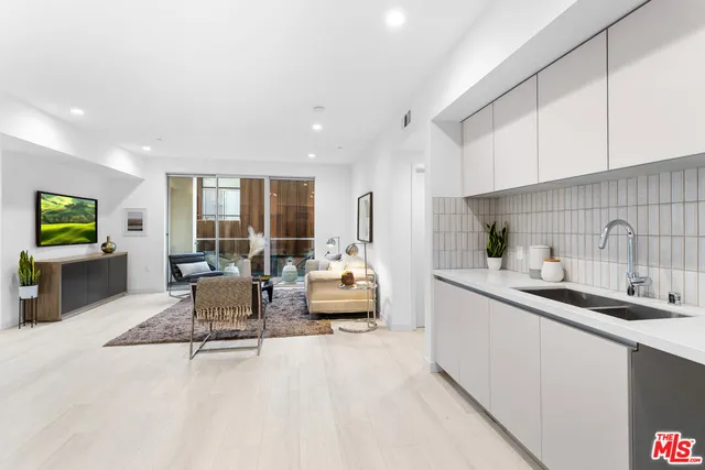 a kitchen with a sink and living room