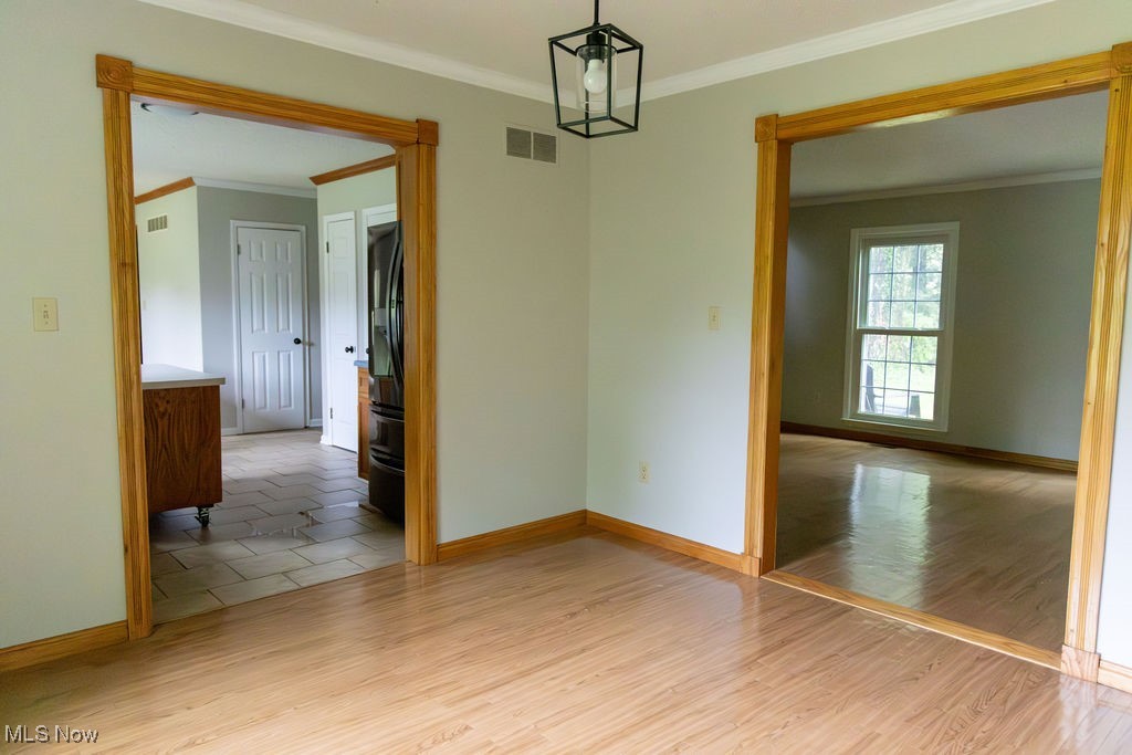 3333 Dayton Road Madison, OH 44057 - Photo 10 of 48 Spare room with crown molding, baseboards, and light wood finished floors