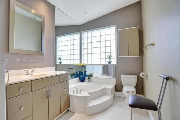 a bathroom with a sink mirror and a bathtub