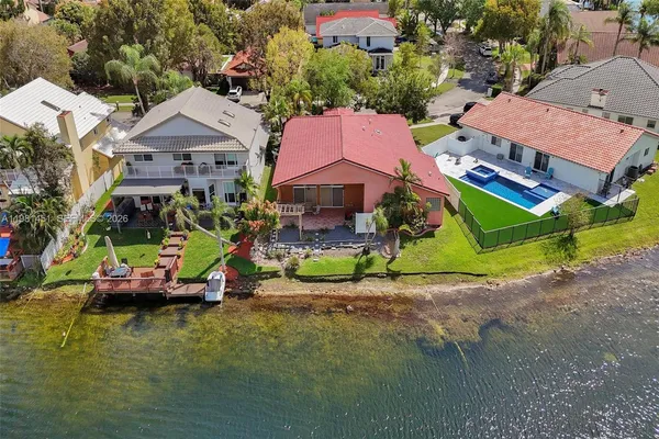 an aerial view of a house with a garden and lake view
