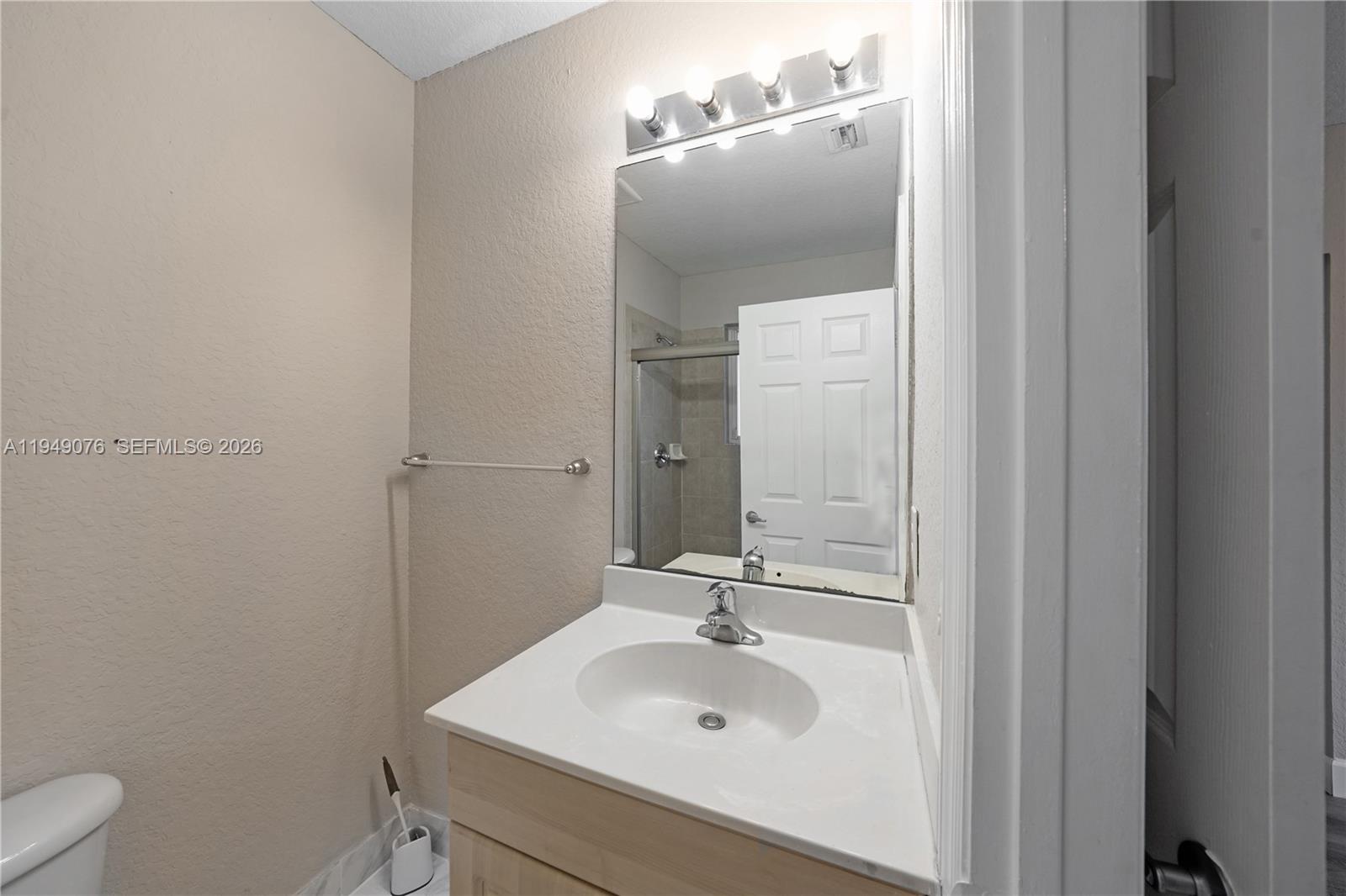 3533 Sonoma Drive Riviera Beach, FL 33404 - Photo 16 of 34 a bathroom with a sink toilet and mirror