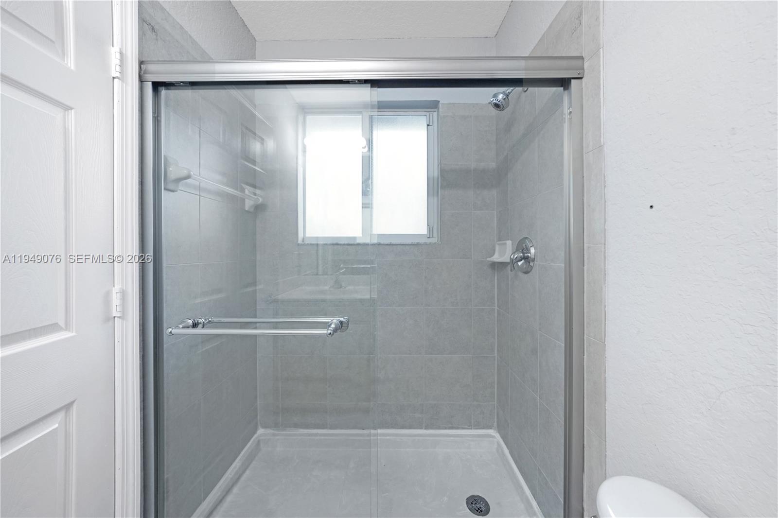 3533 Sonoma Drive Riviera Beach, FL 33404 - Photo 17 of 34 a bathroom with a glass shower door