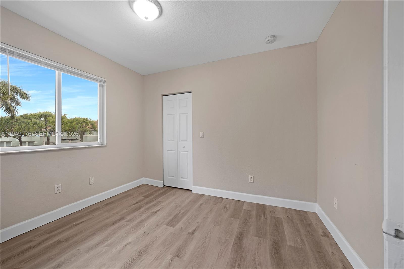 3533 Sonoma Drive Riviera Beach, FL 33404 - Photo 22 of 34 wooden floor in an empty room with a window