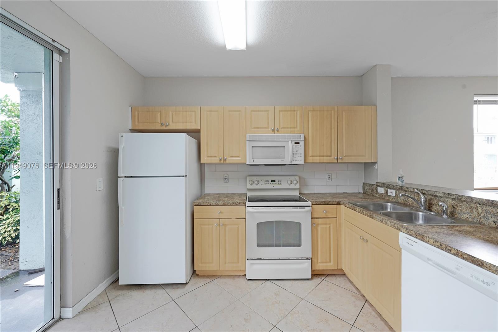 3533 Sonoma Drive Riviera Beach, FL 33404 - Photo 5 of 34 a kitchen with a refrigerator sink stove and cabinets
