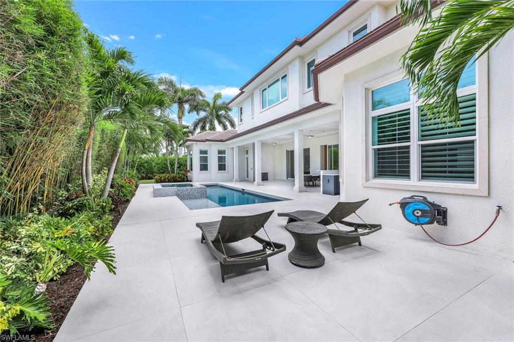 569 Neapolitan Way Naples, FL 34103 - Photo 40 of 50 a view of a patio with table and chairs and potted plants