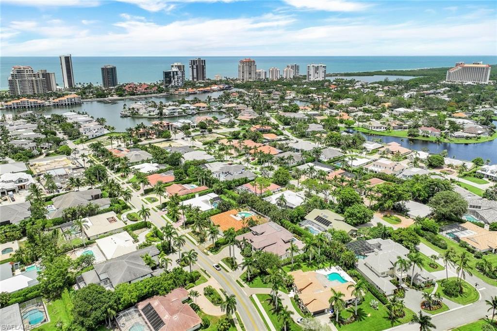 569 Neapolitan Way Naples, FL 34103 - Photo 49 of 50 a large building with lots of trees