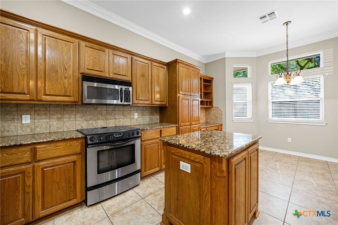 2807 Amber Forest Trail Belton, TX 76513 - Photo 15 of 40 a kitchen with stainless steel appliances granite countertop a stove a sink dishwasher and a microwave oven with white cabinets