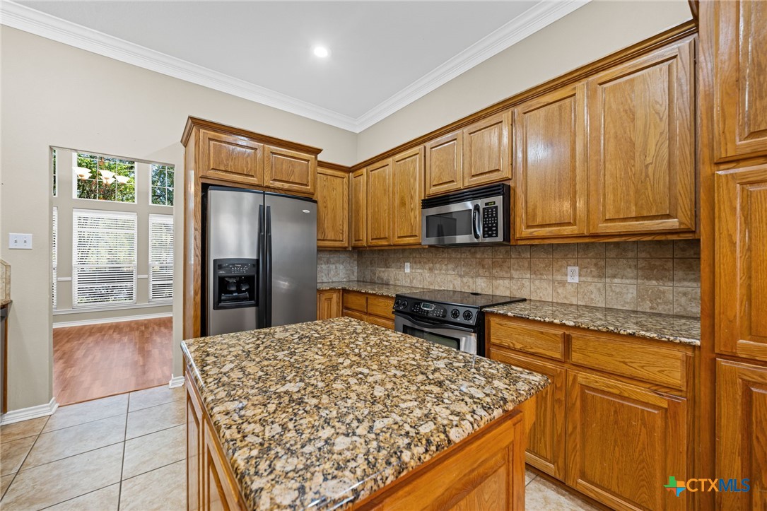 2807 Amber Forest Trail Belton, TX 76513 - Photo 20 of 40 a kitchen with stainless steel appliances granite countertop a refrigerator stove top oven and sink