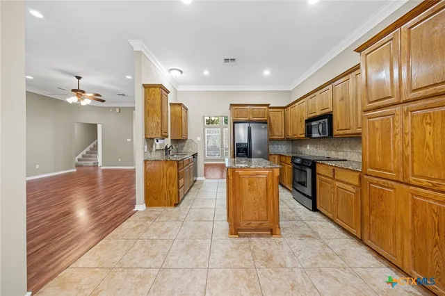 a large kitchen with stainless steel appliances granite countertop a stove a sink dishwasher and a refrigerator