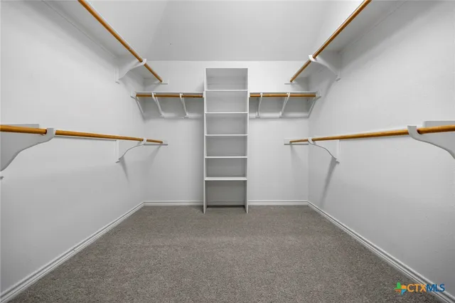 an empty room with windows and ceiling fan