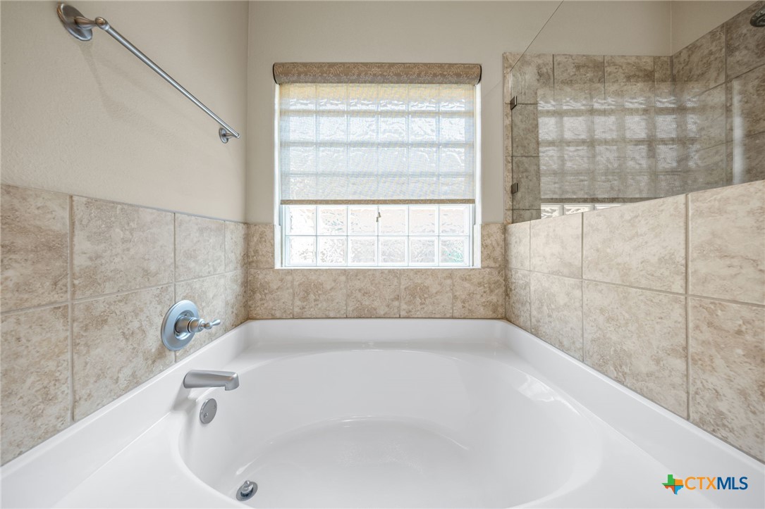 2807 Amber Forest Trail Belton, TX 76513 - Photo 26 of 40 a white bath tub sitting in a bathroom next to a window