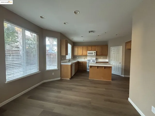 a room with kitchen island a sink wooden floor and view living room