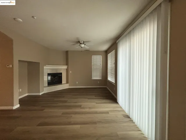 a view of an empty room with window and fire place