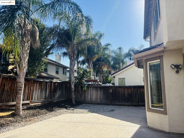 a view of backyard with potted plants and wooden fence