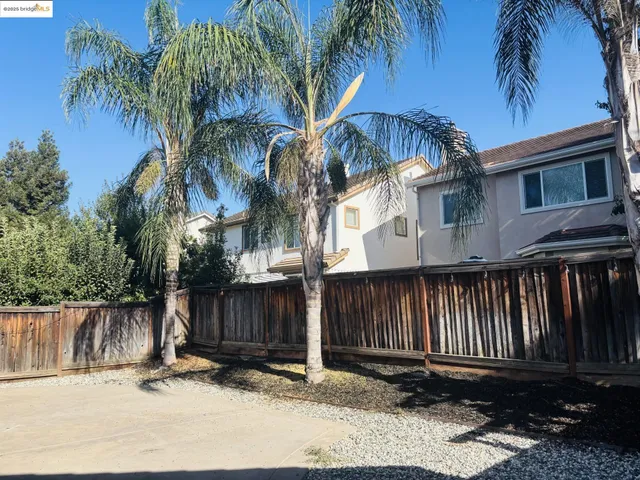 a view of a house with a yard and palm trees