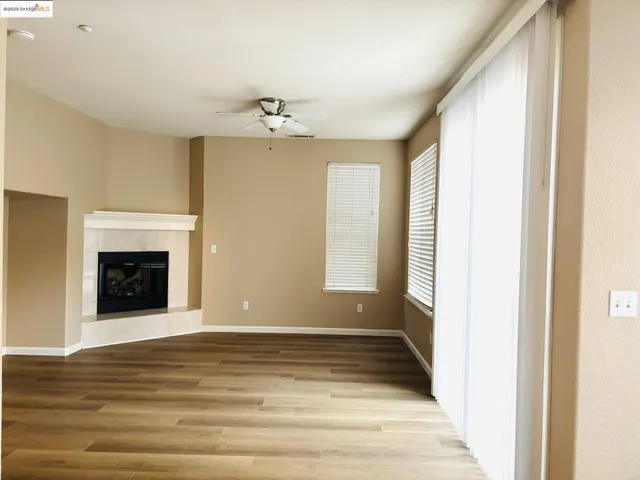 a view of an empty room with a fireplace and a window