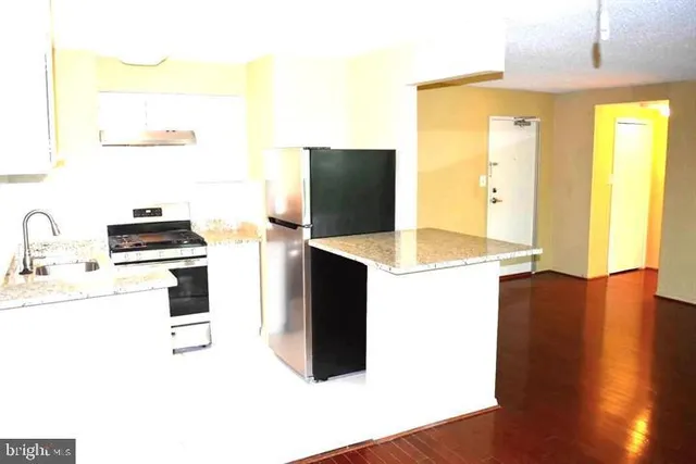 a kitchen with a refrigerator and a stove top oven