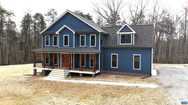 a front view of a house with a yard covered in snow