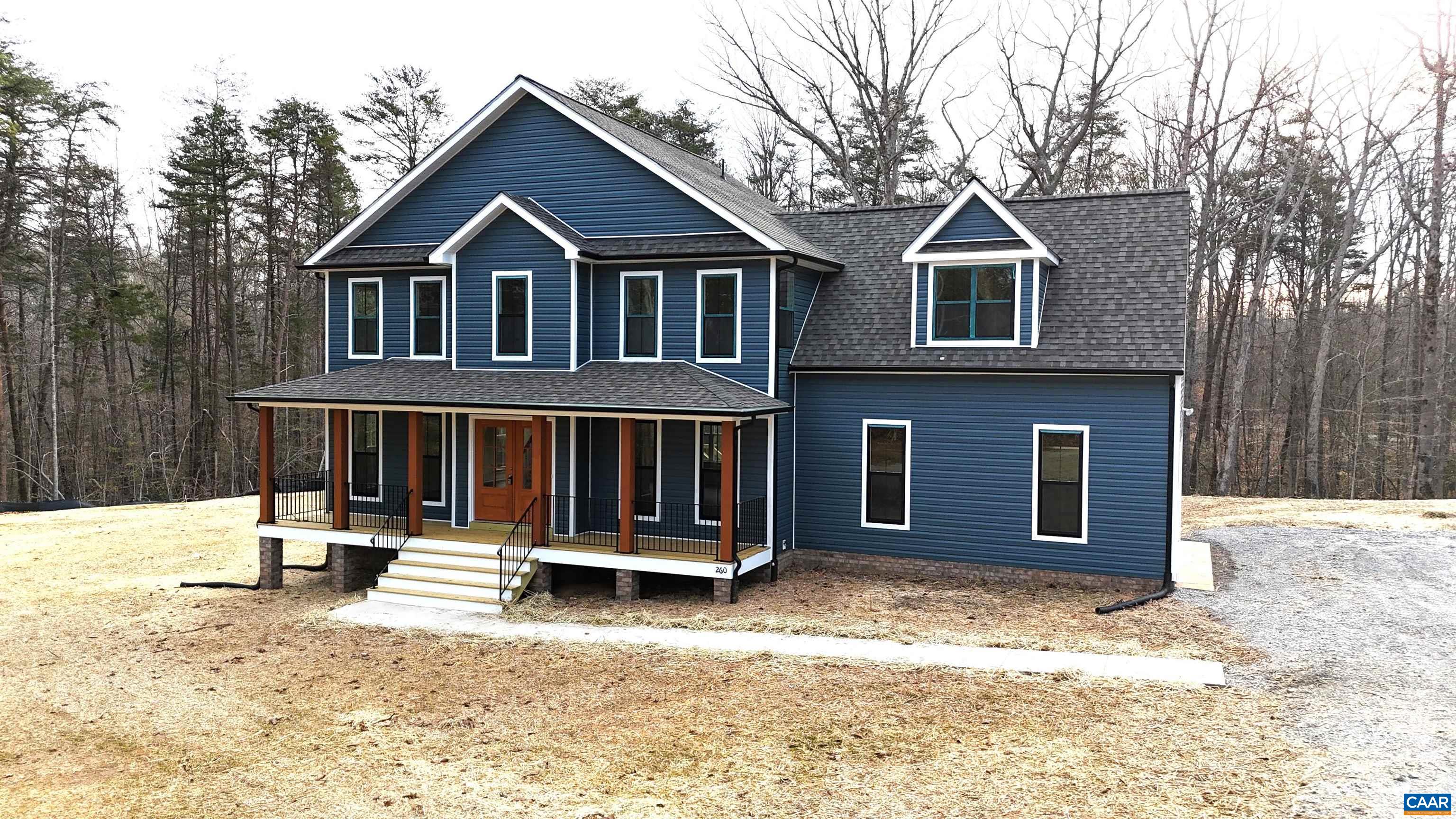 a front view of a house with a yard covered in snow