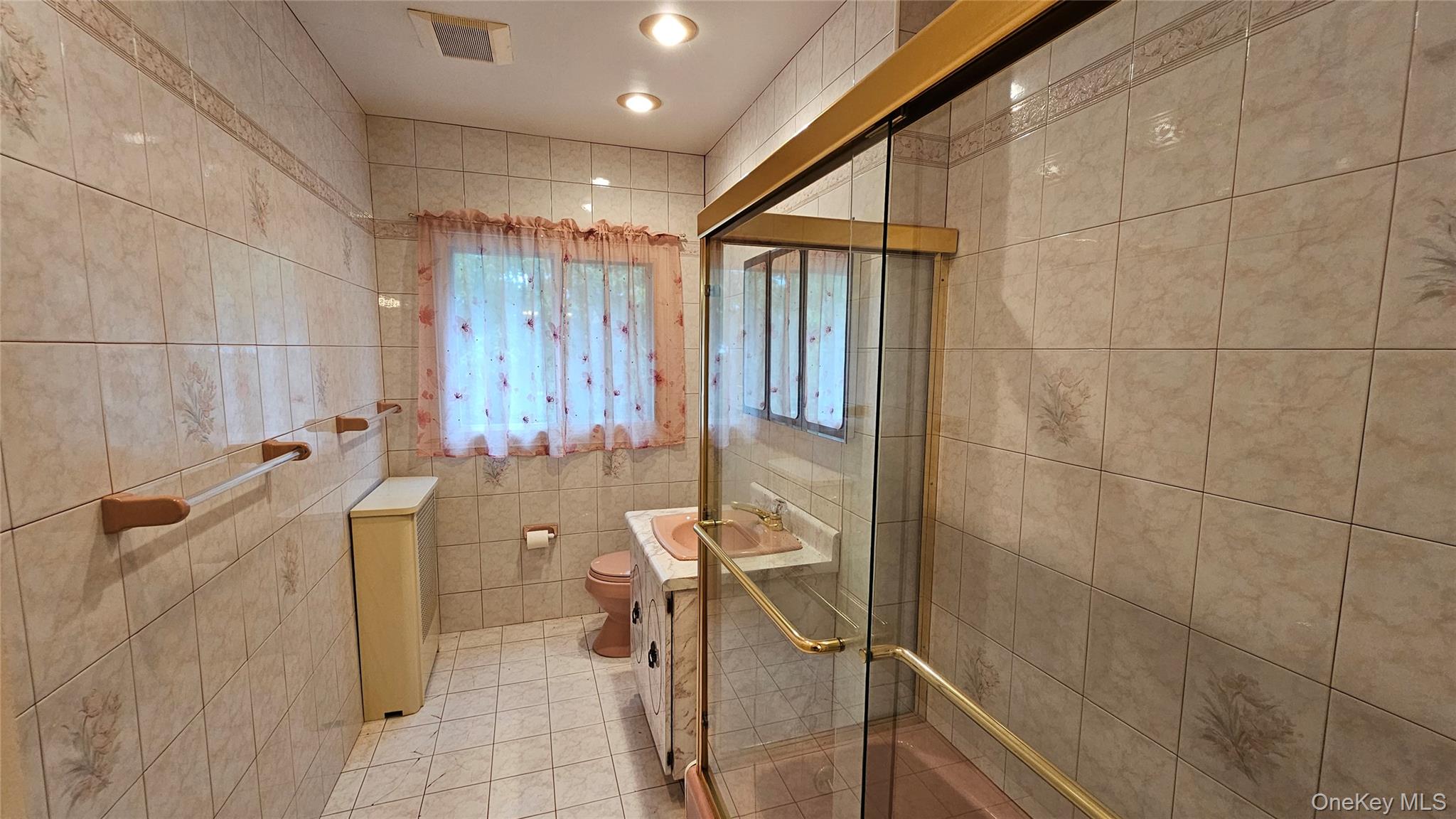 108-11 65th Road Queens, NY 11375 - Photo 19 of 22 Bathroom featuring light tile patterned floors, a shower stall, tile walls, and vanity