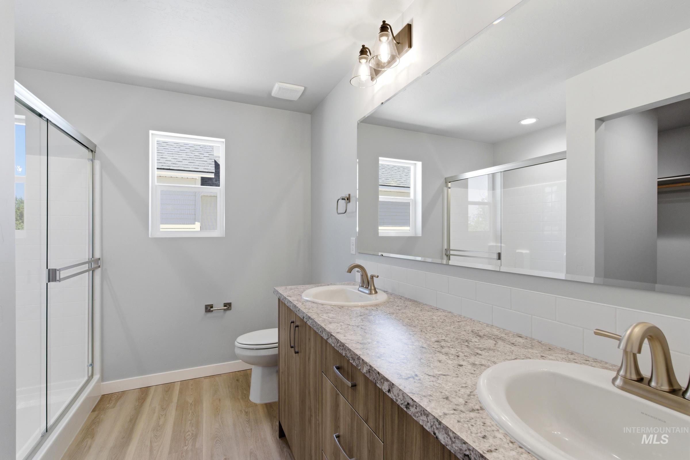 2374 West Fallon Loop Nampa, ID 83651 - Photo 24 of 24 Dual vanity with laminate countertops, wood-finish cabinetry, and brushed nickel fixtures