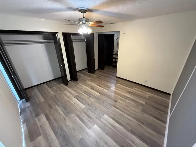 a view of a livingroom with wooden floor and staircase
