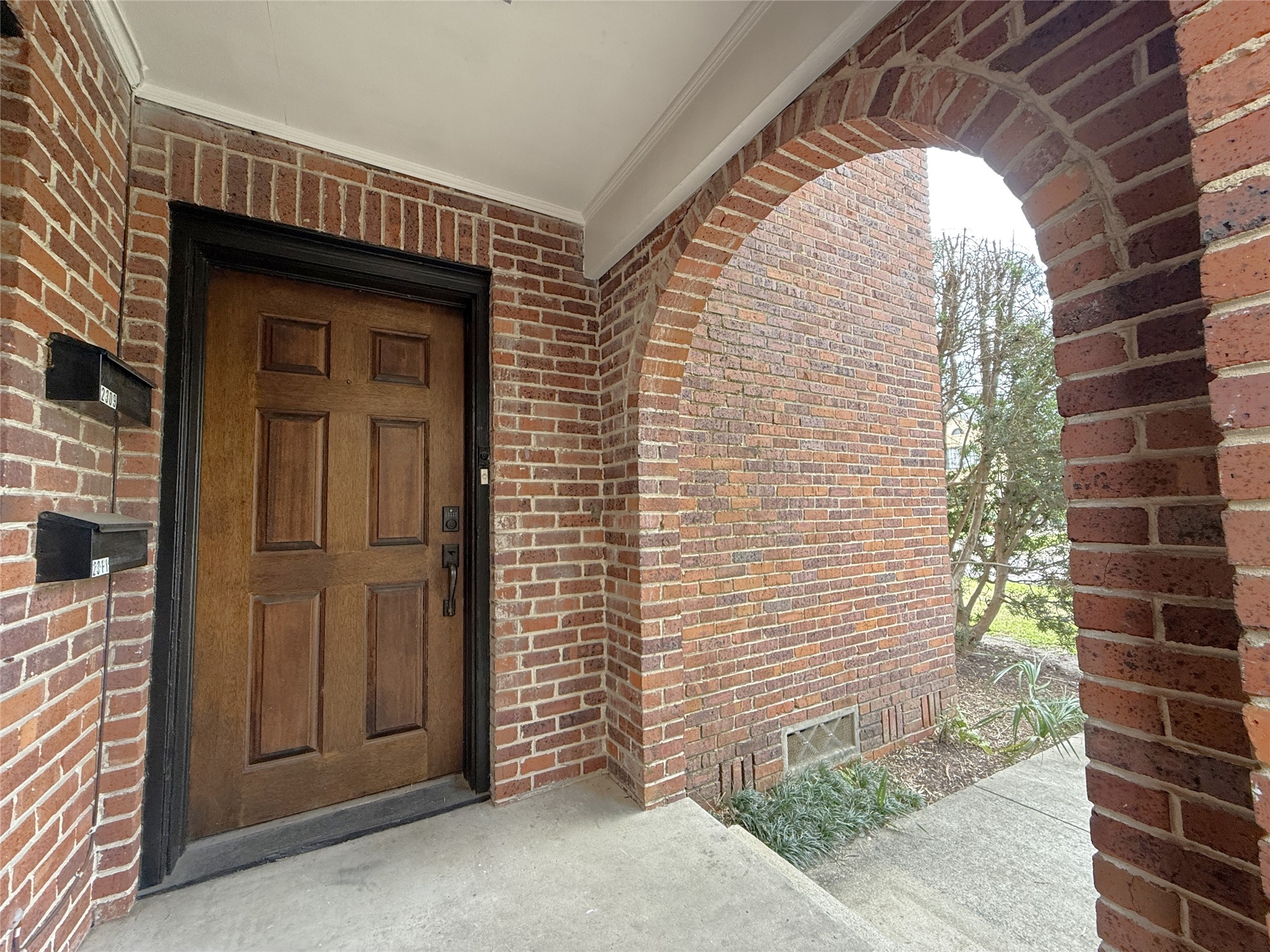 2311 Wroxton Road Houston, TX 77005 - Photo 22 of 24 Past the arch, the front door into 2311 Wroxton is on the right.