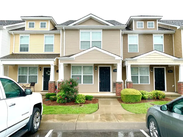 a front view of a house with a yard and potted plants
