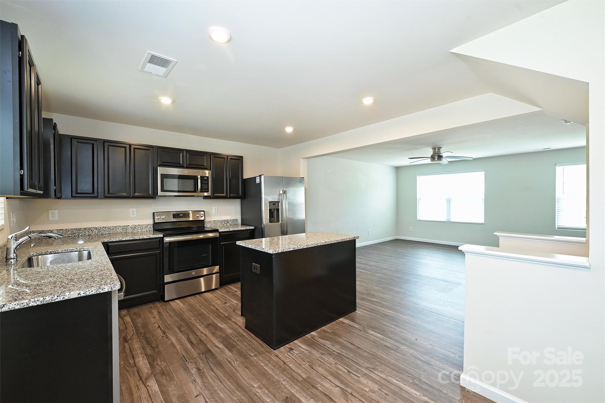825 Renee Avenue Fort Mill, SC 29715 - Photo 13 of 30 a kitchen with stainless steel appliances granite countertop a sink dishwasher stove top oven and wooden cabinets