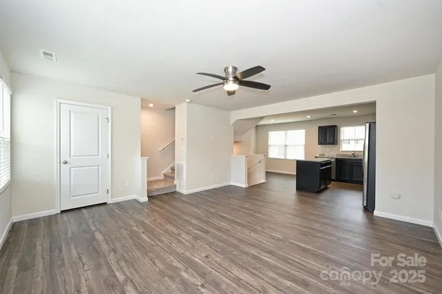 a view of an empty room with window and wooden floor